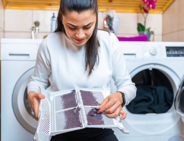 A homeowner in Phoenix looking disgusted while cleaning lint off her dryer filter