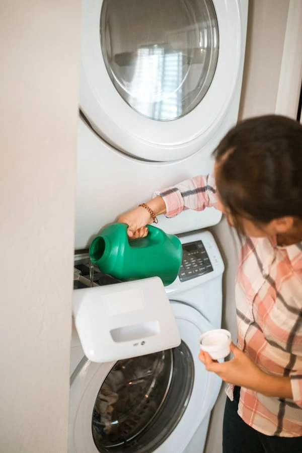 A homeowner in Avondale adding detergent to a washer repaired by ACR