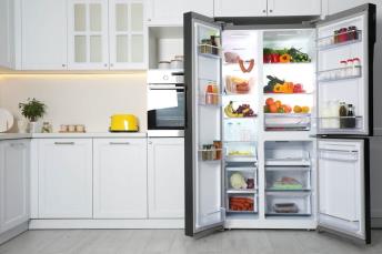 a staged kitchen set with an open refrigerator off center-ed