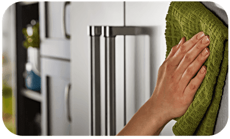 Hand wiping down refrigerator door - Don’t let your food go bad—call ACR for Cave Creek refrigerator repair today!